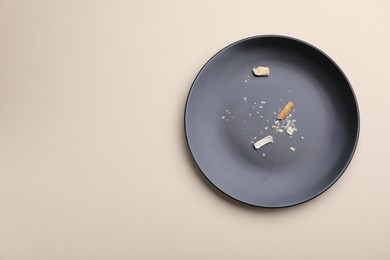 Photo of Dirty plate with bread crumbs on beige background, top view. Space for text