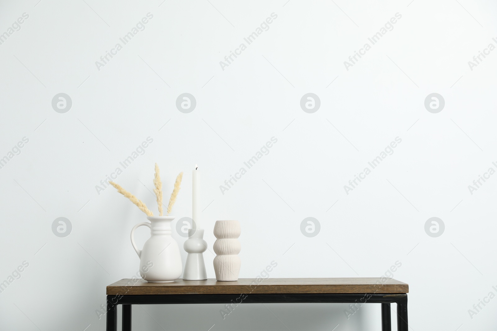 Different decor on wooden table near white wall indoors Photo of Different decor on wooden table near white wall indoors