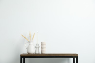 Photo of Different decor on wooden table near white wall indoors