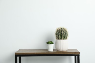 Photo of Beautiful floral decor on wooden table near white wall indoors