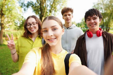 Photo of Group of teenagers taking selfie in park