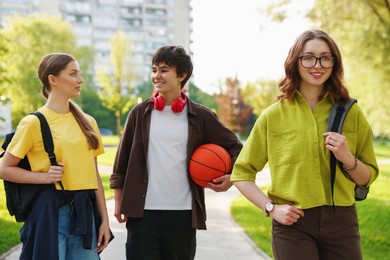Photo of Three teenagers spending time together in park