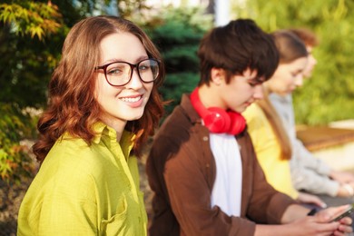 Photo of Teenagers spending time together in park, selective focus
