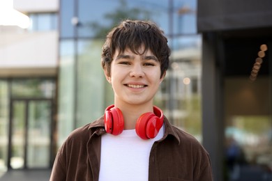 Photo of Portrait of happy teenager with headphones outdoors