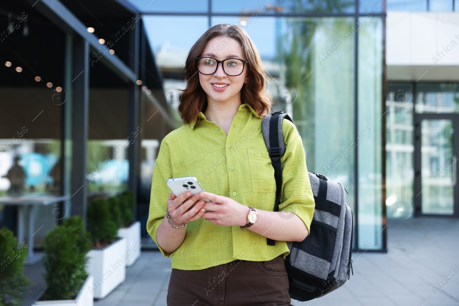 Teenage girl with smartphone and backpack outdoors Photo of Teenage girl with smartphone and backpack outdoors