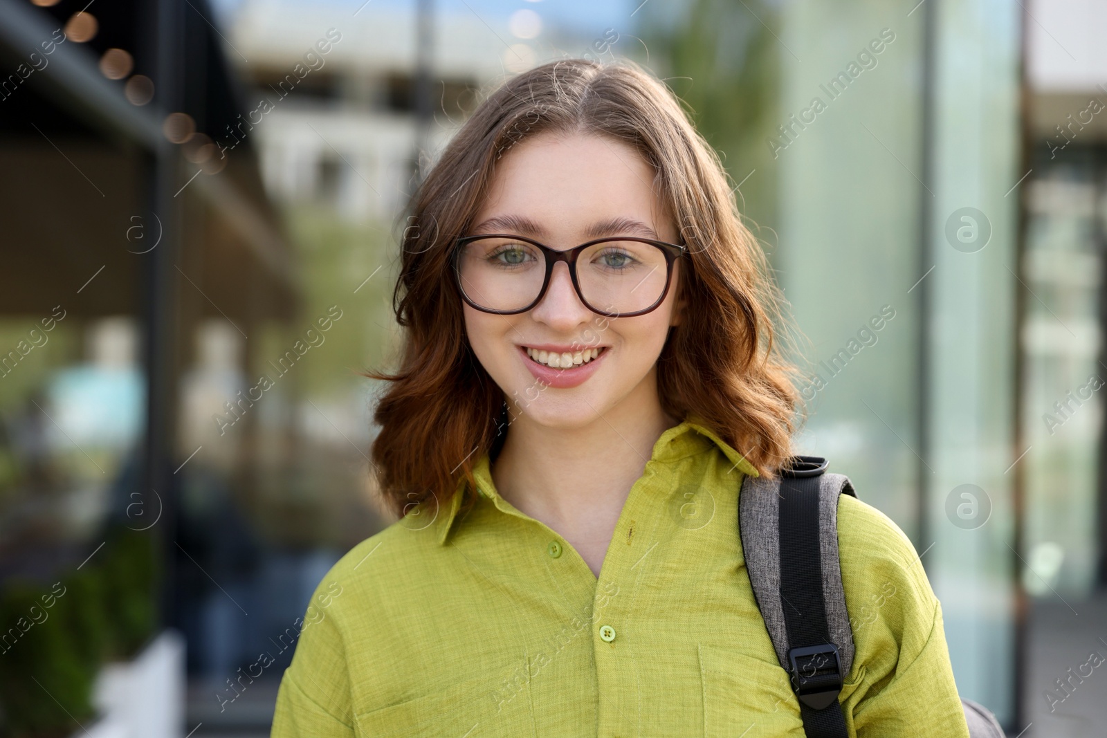 Teenage girl with backpack near building outdoors Photo of Teenage girl with backpack near building outdoors