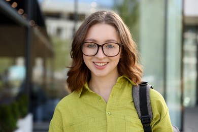 Photo of Teenage girl with backpack near building outdoors