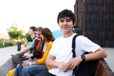 Photo of Teenagers spending time together outdoors, selective focus