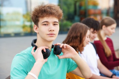 Photo of Teenagers spending time together outdoors, selective focus