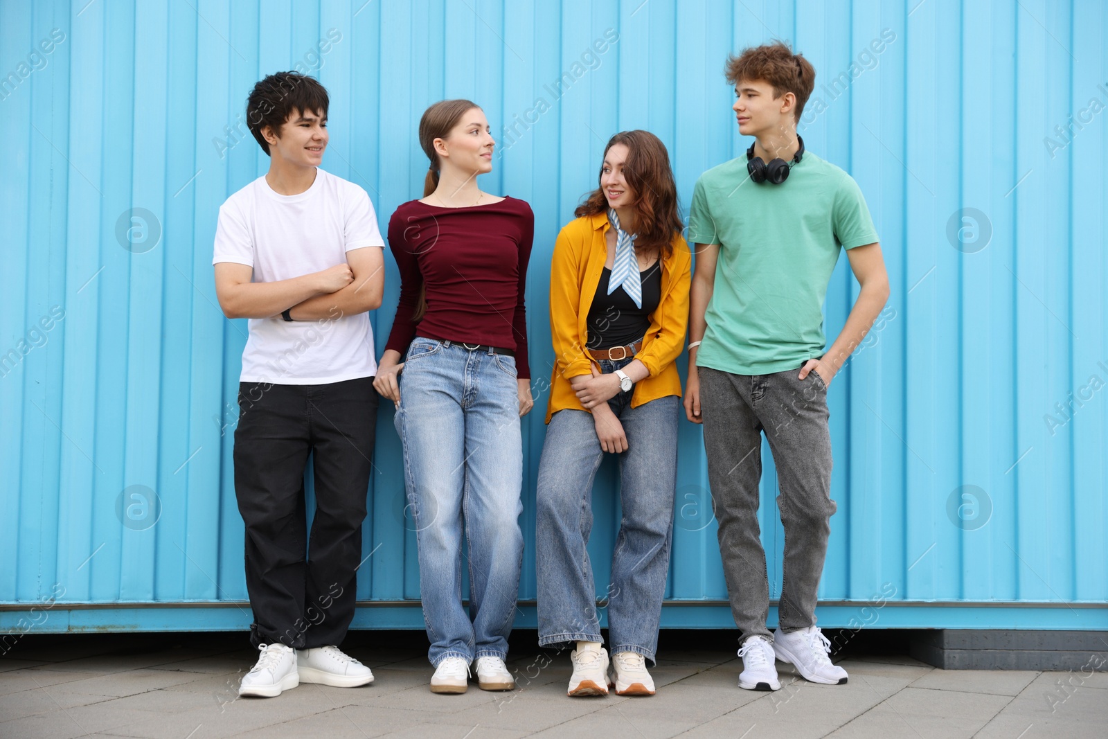 Group of teenagers posing near building outdoors Photo of Group of teenagers posing near building outdoors