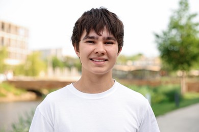 Photo of Portrait of happy teenage boy posing outdoors
