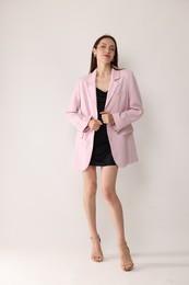 Photo of Full-length portrait of beautiful woman in stylish outfit on white background