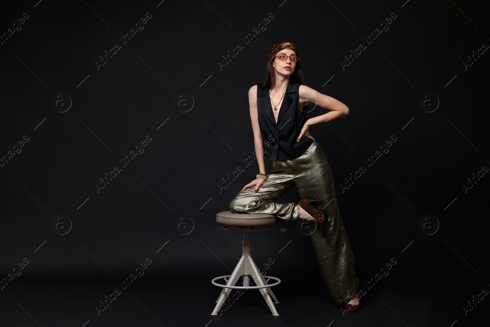 Beautiful woman in stylish outfit posing on black background, space for text Photo of Beautiful woman in stylish outfit posing on black background, space for text