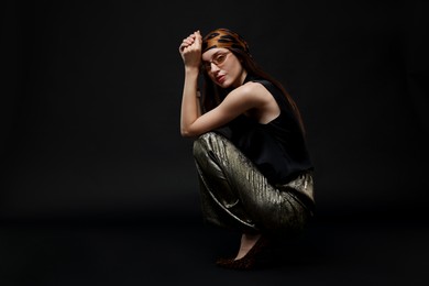 Photo of Full-length portrait of beautiful woman in stylish outfit on black background