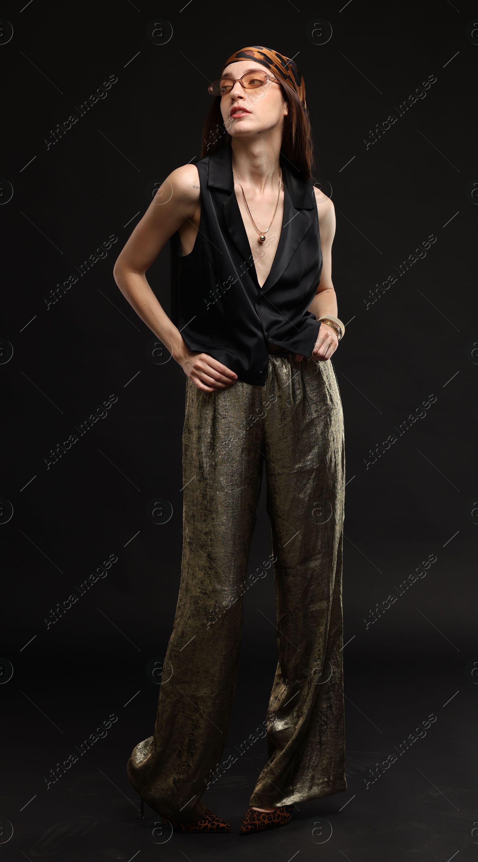 Full-length portrait of beautiful woman in stylish outfit on black background Photo of Full-length portrait of beautiful woman in stylish outfit on black background