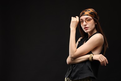 Photo of Portrait of beautiful woman in stylish outfit on black background, space for text