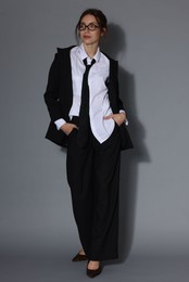 Photo of Full-length portrait of beautiful woman in stylish outfit on light grey background