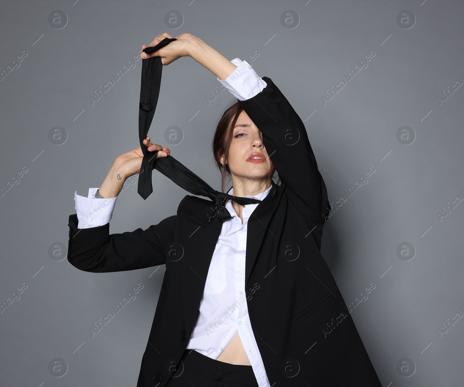 Portrait of beautiful woman in stylish outfit on light grey background Photo of Portrait of beautiful woman in stylish outfit on light grey background