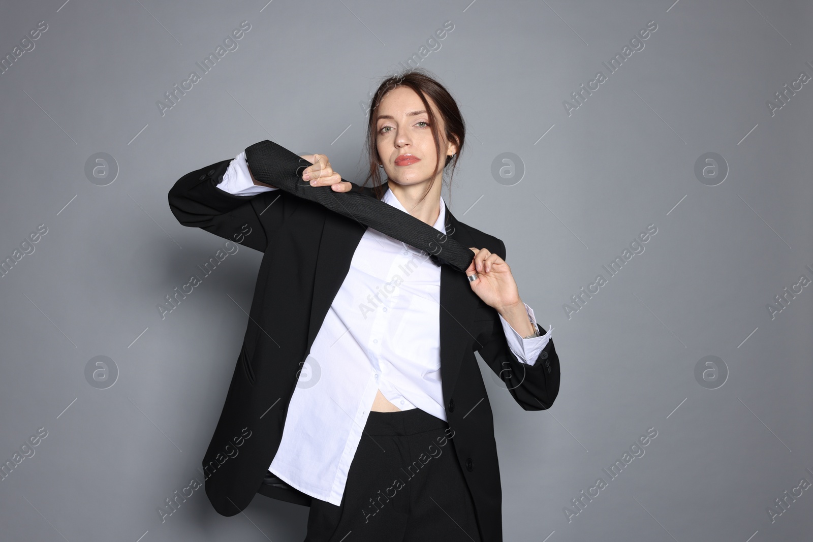 Portrait of beautiful woman in stylish outfit on light grey background Photo of Portrait of beautiful woman in stylish outfit on light grey background