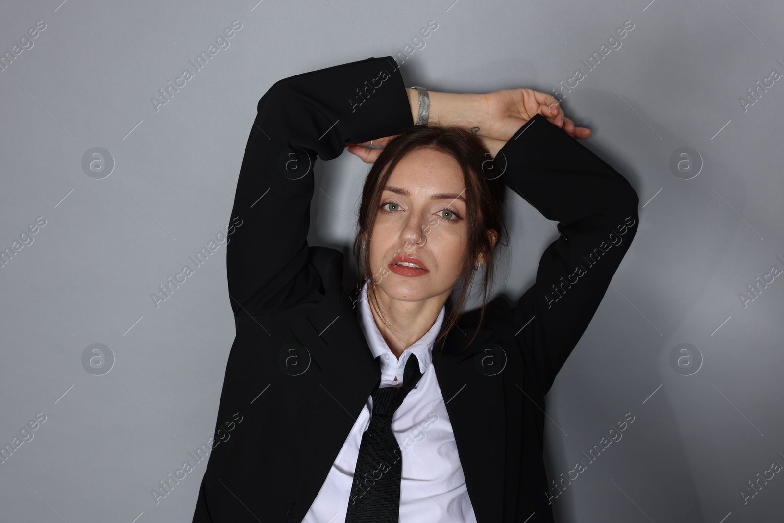 Portrait of beautiful woman in stylish outfit on light grey background Photo of Portrait of beautiful woman in stylish outfit on light grey background