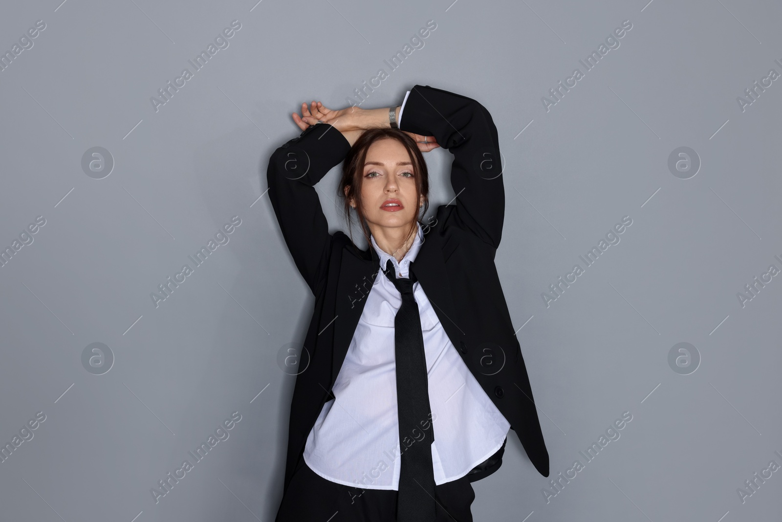 Portrait of beautiful woman in stylish outfit on light grey background Photo of Portrait of beautiful woman in stylish outfit on light grey background