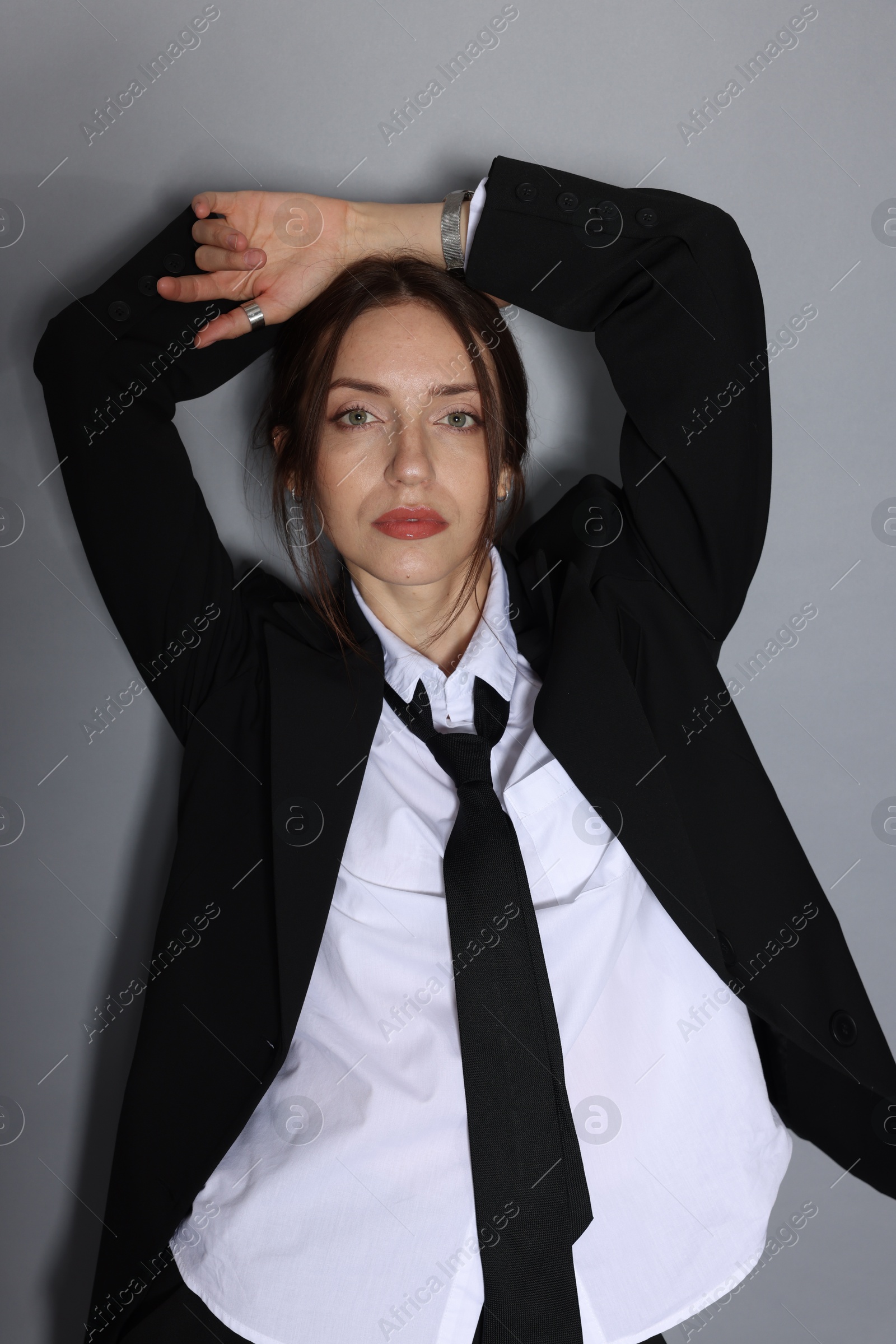 Portrait of beautiful woman in stylish outfit on light grey background Photo of Portrait of beautiful woman in stylish outfit on light grey background