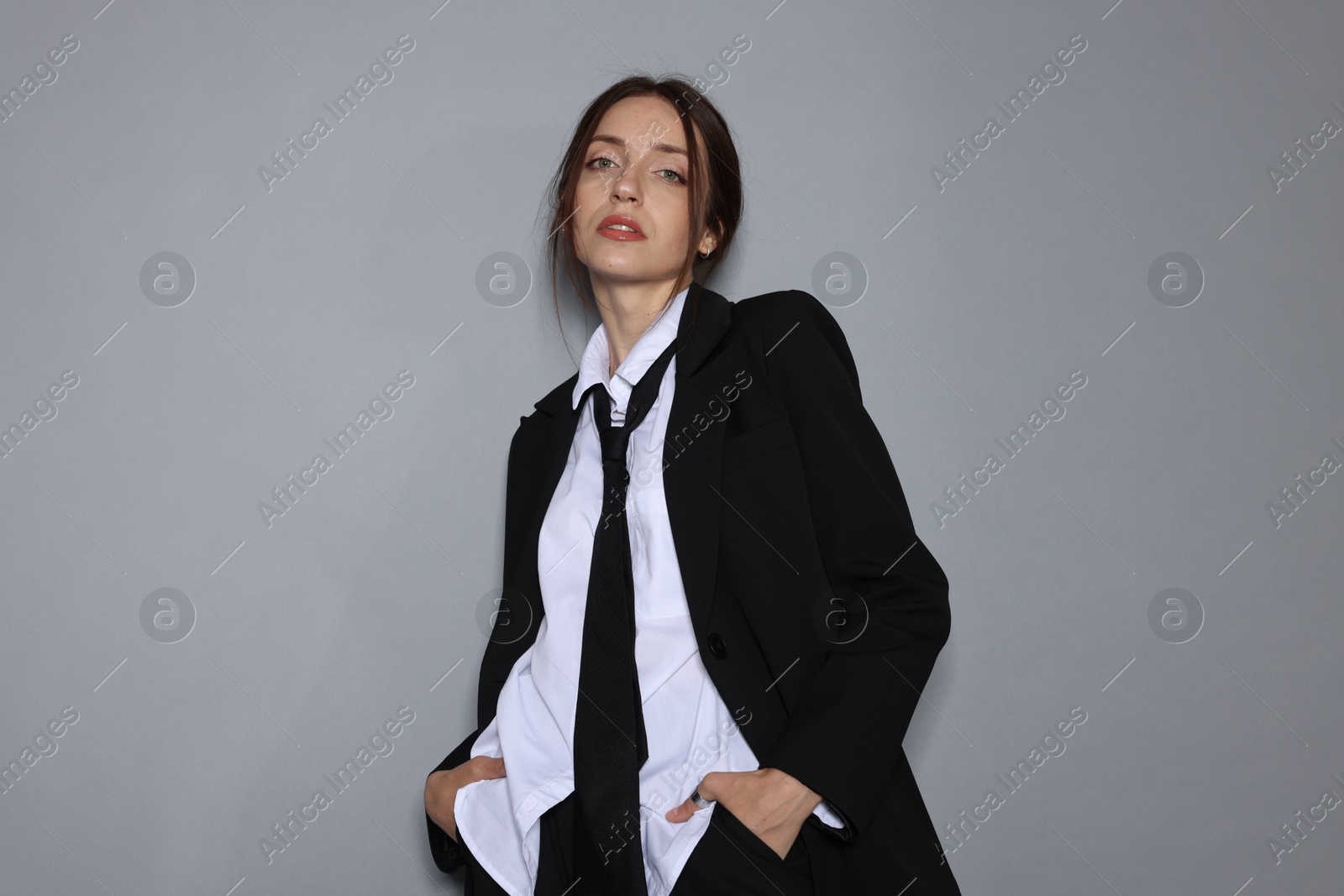 Portrait of beautiful woman in stylish outfit on light grey background Photo of Portrait of beautiful woman in stylish outfit on light grey background