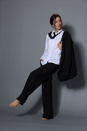 Photo of Full-length portrait of beautiful woman in stylish outfit on light grey background