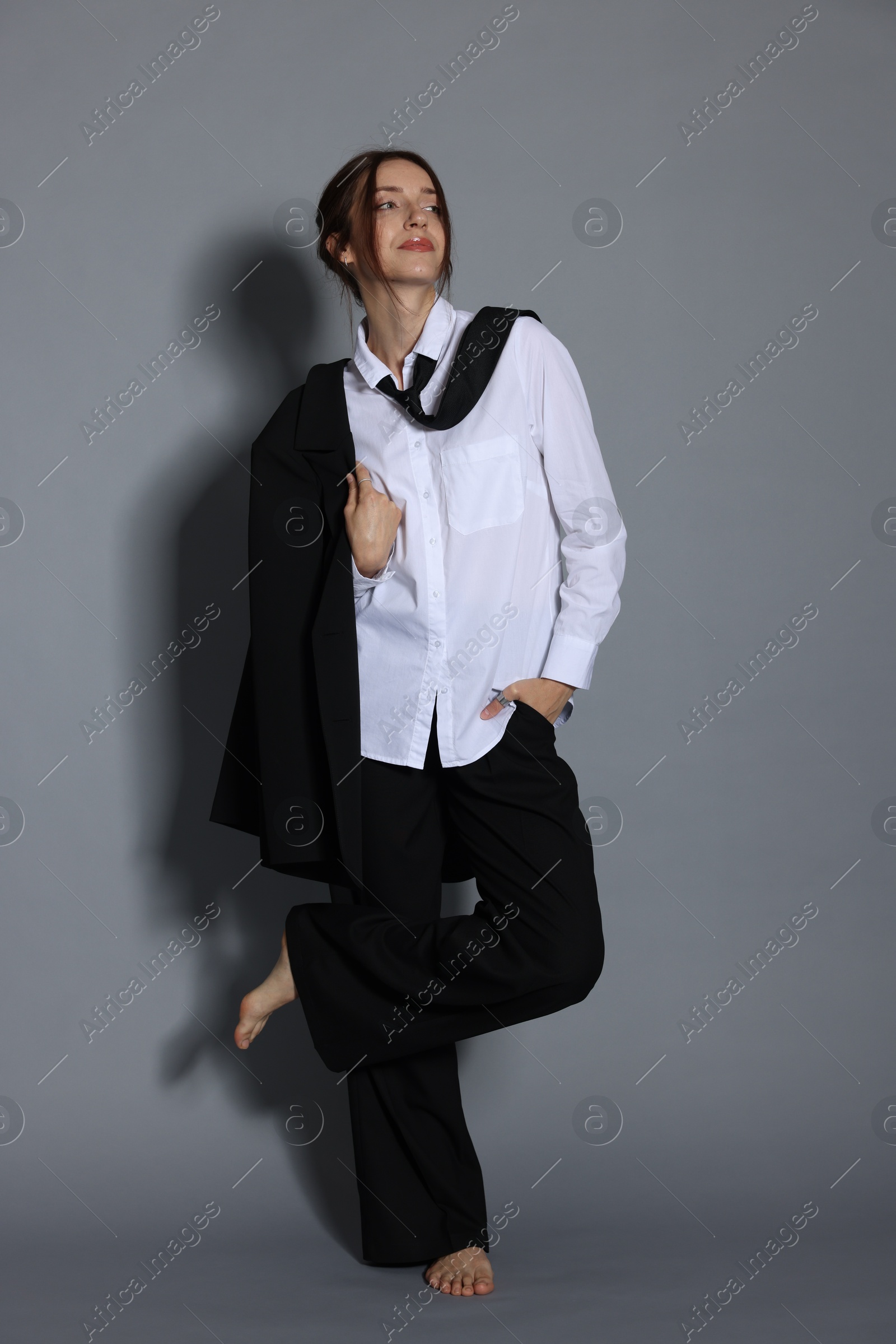 Full-length portrait of beautiful woman in stylish outfit on light grey background Photo of Full-length portrait of beautiful woman in stylish outfit on light grey background
