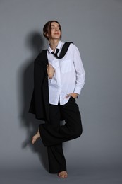 Photo of Full-length portrait of beautiful woman in stylish outfit on light grey background