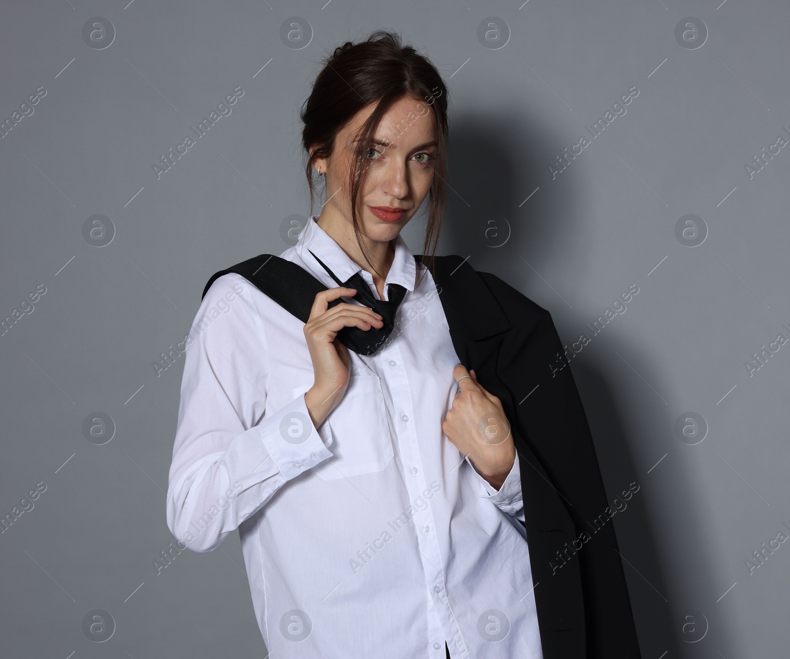Portrait of beautiful woman in stylish outfit on light grey background Photo of Portrait of beautiful woman in stylish outfit on light grey background