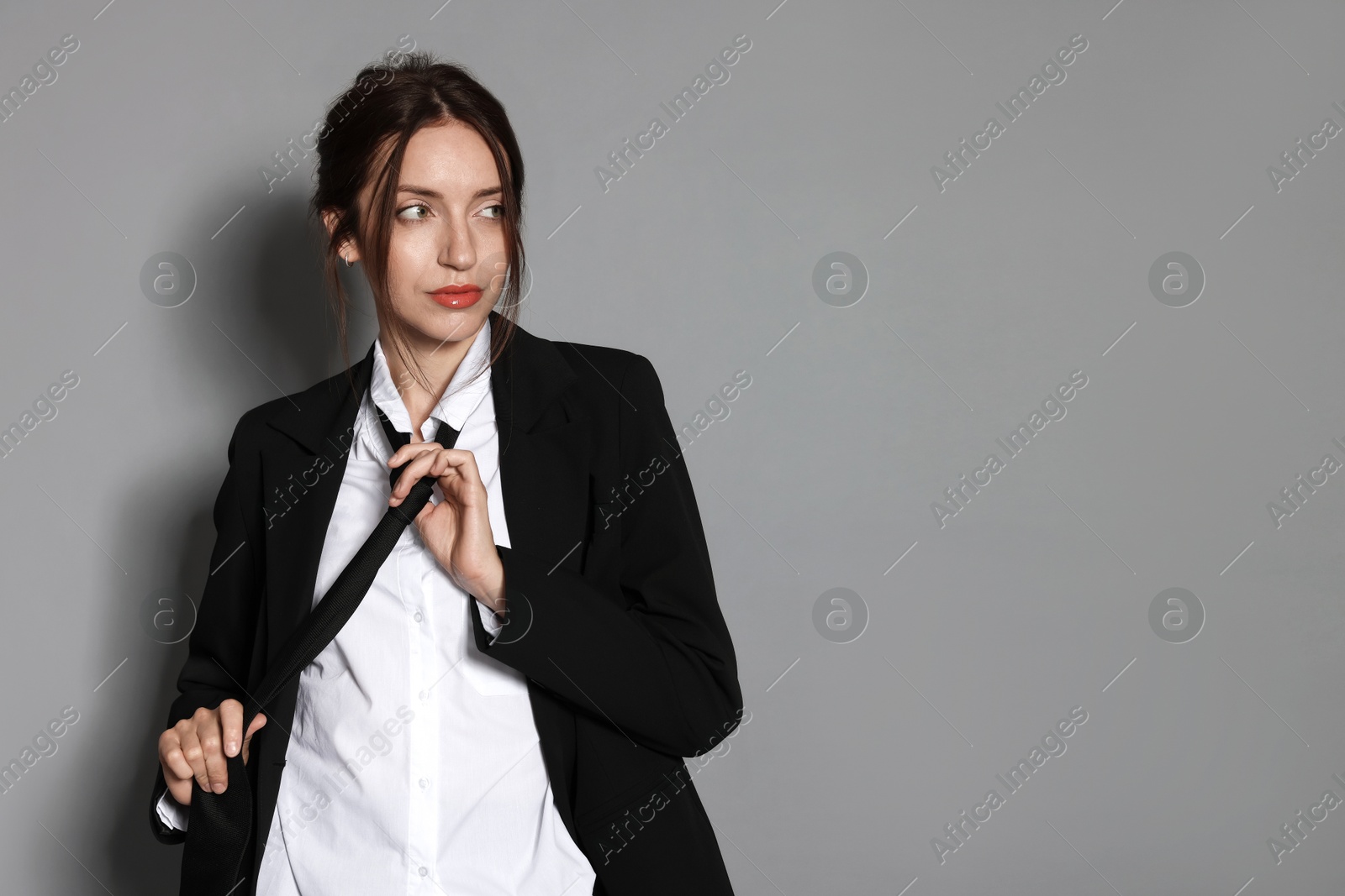 Portrait of beautiful woman in stylish outfit on light grey background, space for text Photo of Portrait of beautiful woman in stylish outfit on light grey background, space for text