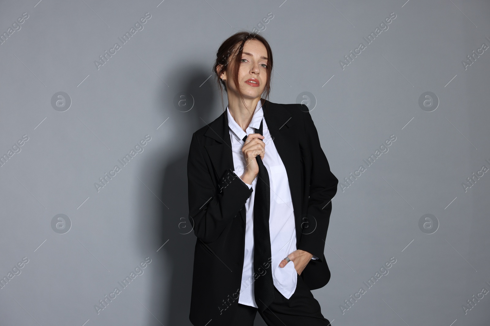Portrait of beautiful woman in stylish outfit on light grey background Photo of Portrait of beautiful woman in stylish outfit on light grey background