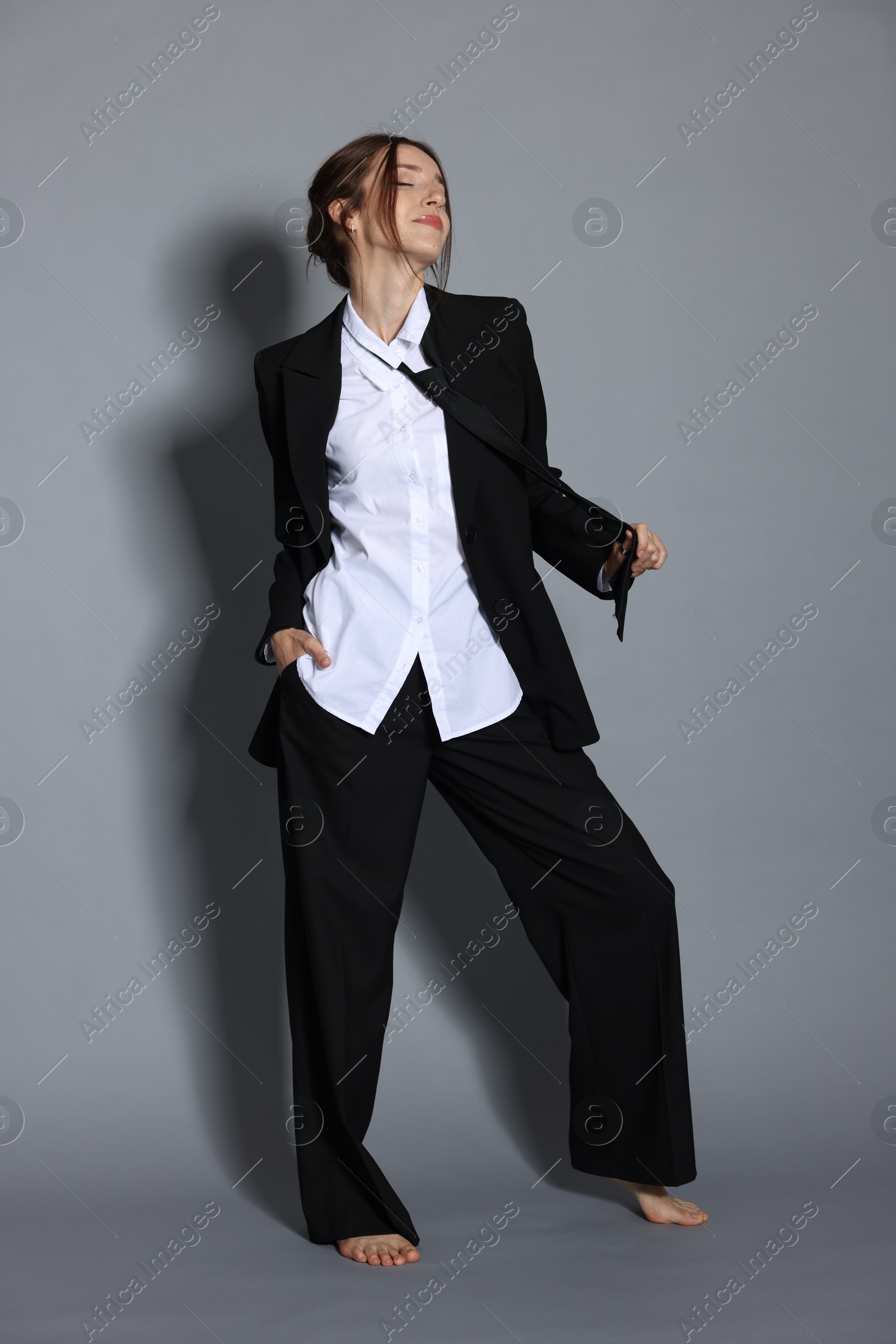 Full-length portrait of beautiful woman in stylish outfit on light grey background Photo of Full-length portrait of beautiful woman in stylish outfit on light grey background