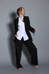 Photo of Full-length portrait of beautiful woman in stylish outfit on light grey background