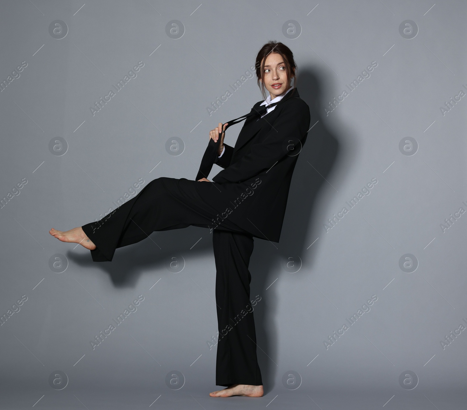 Full-length portrait of beautiful woman in stylish outfit on light grey background Photo of Full-length portrait of beautiful woman in stylish outfit on light grey background