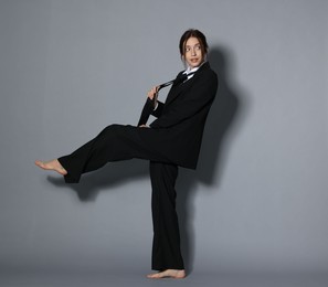 Photo of Full-length portrait of beautiful woman in stylish outfit on light grey background