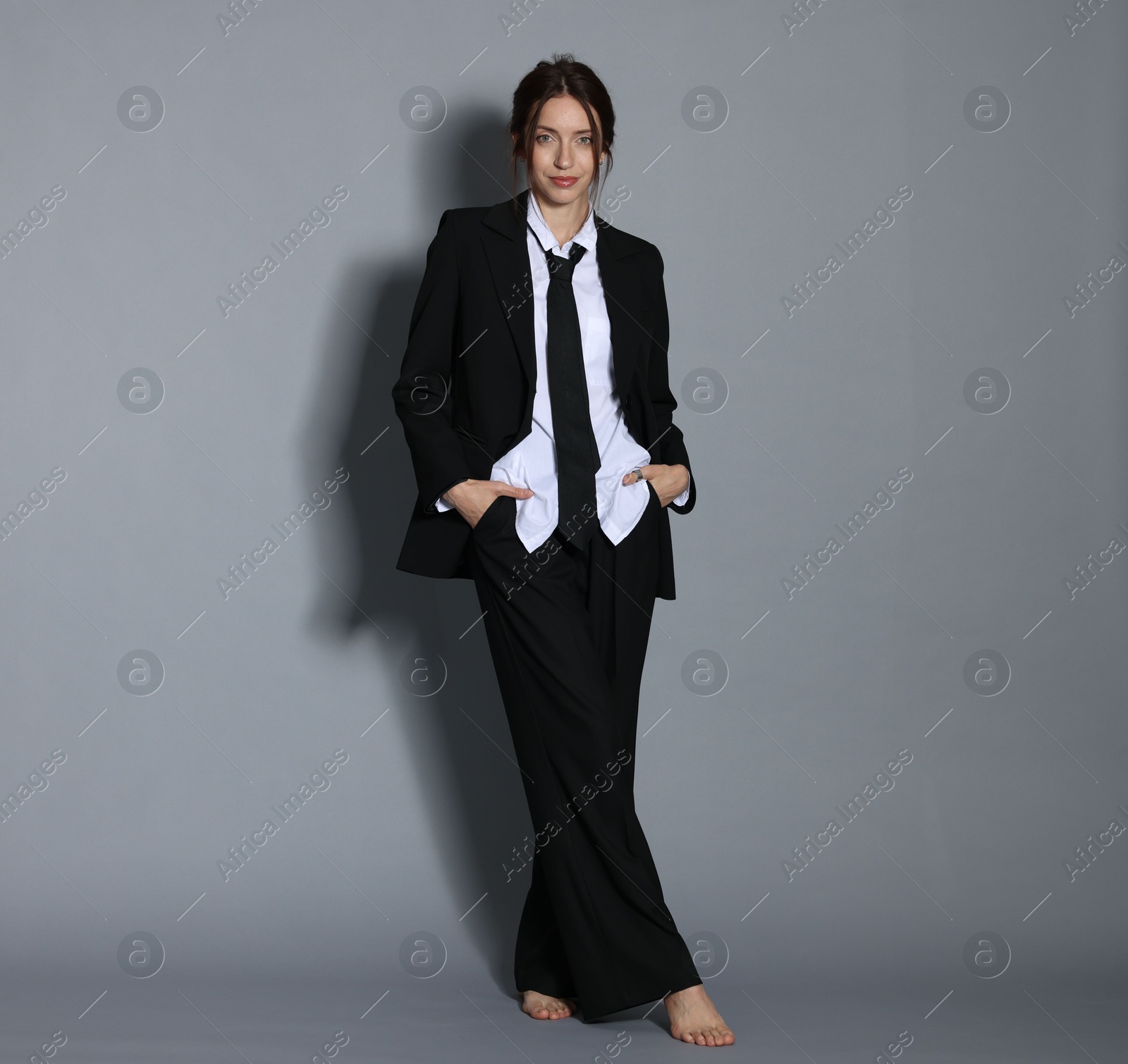 Full-length portrait of beautiful woman in stylish outfit on light grey background Photo of Full-length portrait of beautiful woman in stylish outfit on light grey background