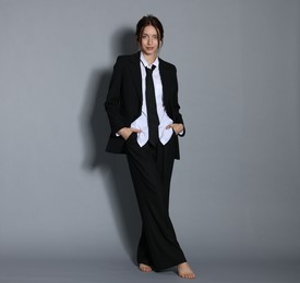 Photo of Full-length portrait of beautiful woman in stylish outfit on light grey background