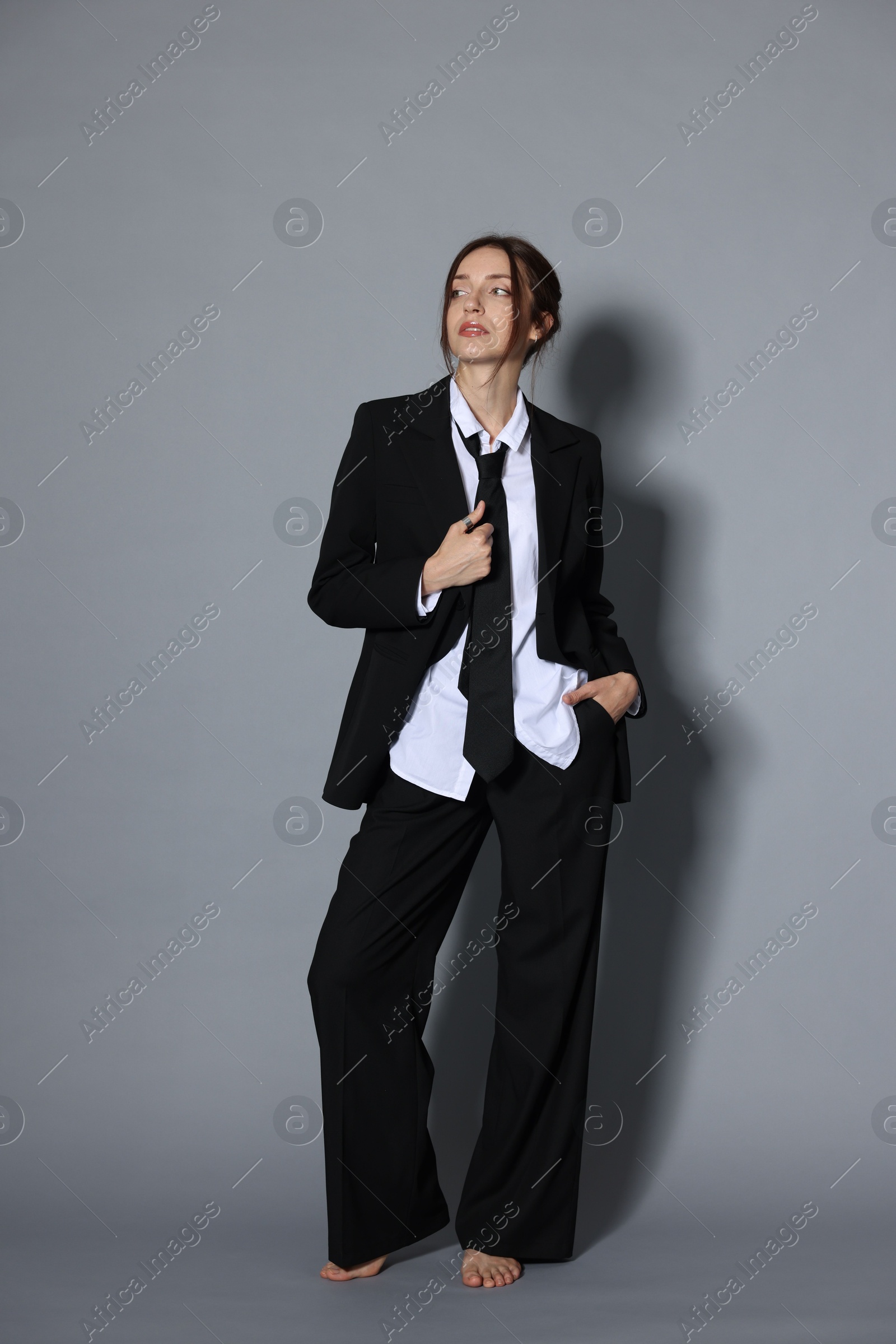 Full-length portrait of beautiful woman in stylish outfit on light grey background Photo of Full-length portrait of beautiful woman in stylish outfit on light grey background