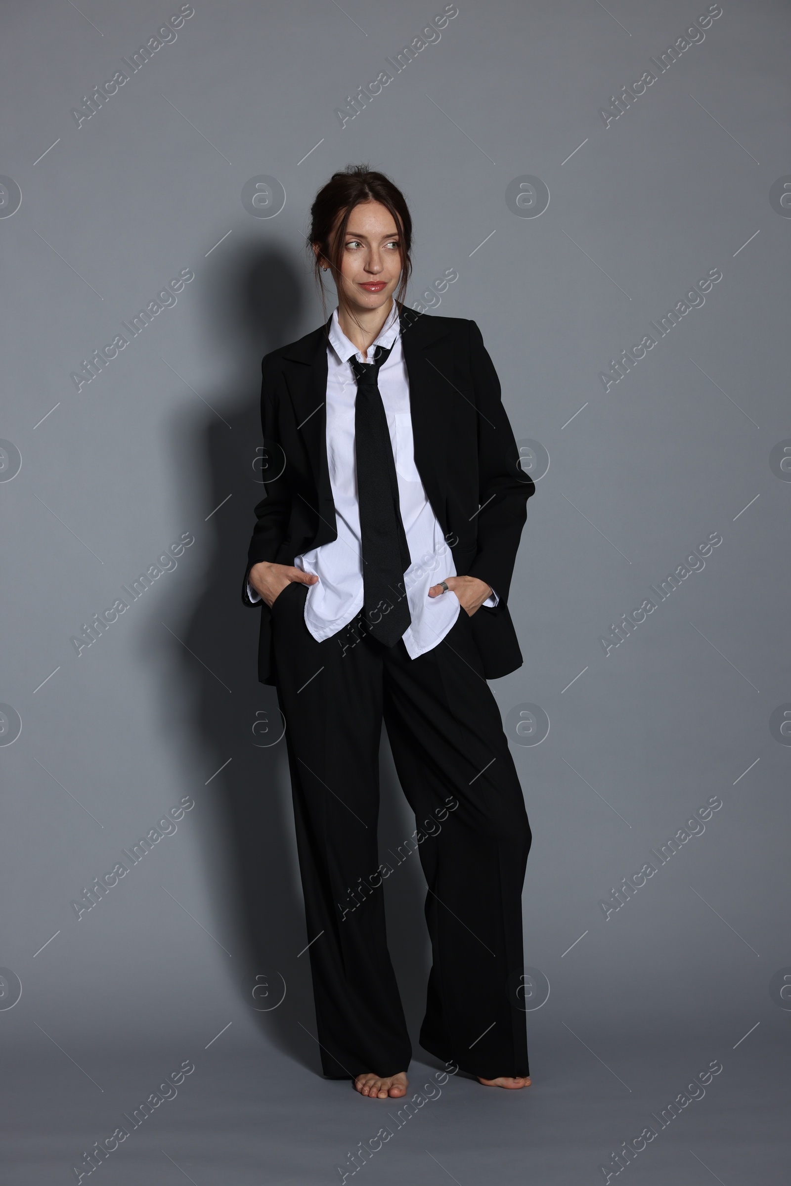 Full-length portrait of beautiful woman in stylish outfit on light grey background Photo of Full-length portrait of beautiful woman in stylish outfit on light grey background
