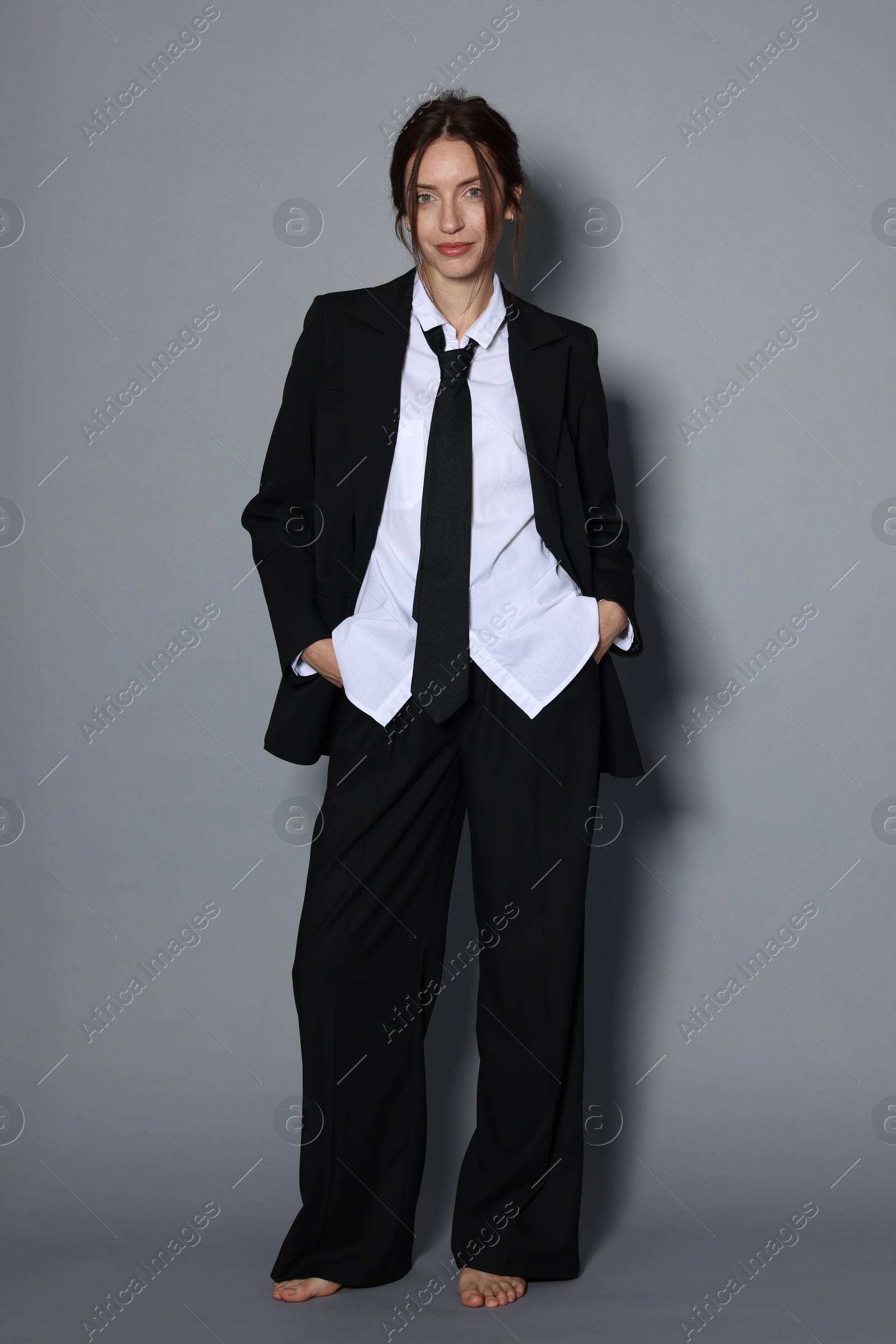 Full-length portrait of beautiful woman in stylish outfit on light grey background Photo of Full-length portrait of beautiful woman in stylish outfit on light grey background