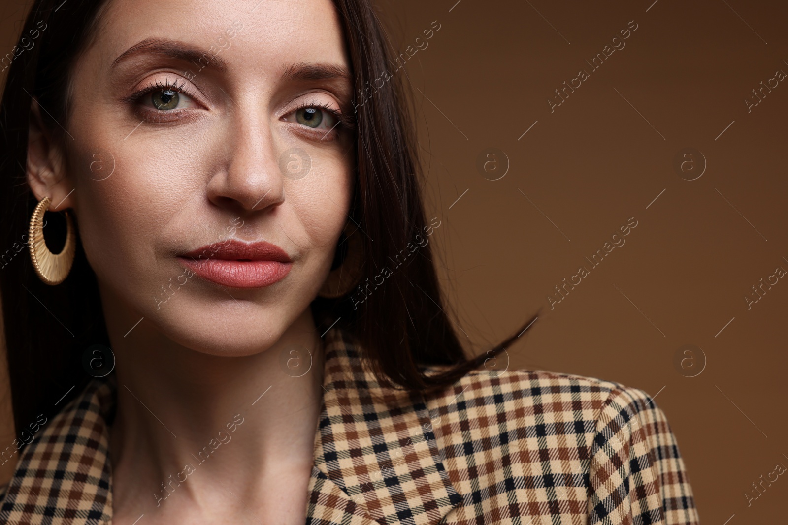 Beautiful woman in stylish outfit on brown background, closeup. Space for text Photo of Beautiful woman in stylish outfit on brown background, closeup. Space for text
