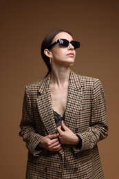 Photo of Portrait of beautiful woman in stylish outfit on brown background