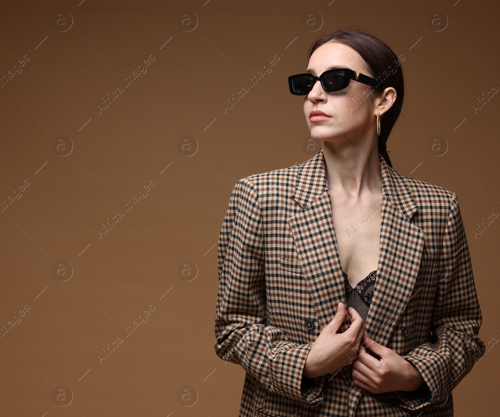 Portrait of beautiful woman in stylish outfit on brown background, space for text Photo of Portrait of beautiful woman in stylish outfit on brown background, space for text