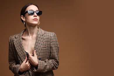 Photo of Portrait of beautiful woman in stylish outfit on brown background, space for text