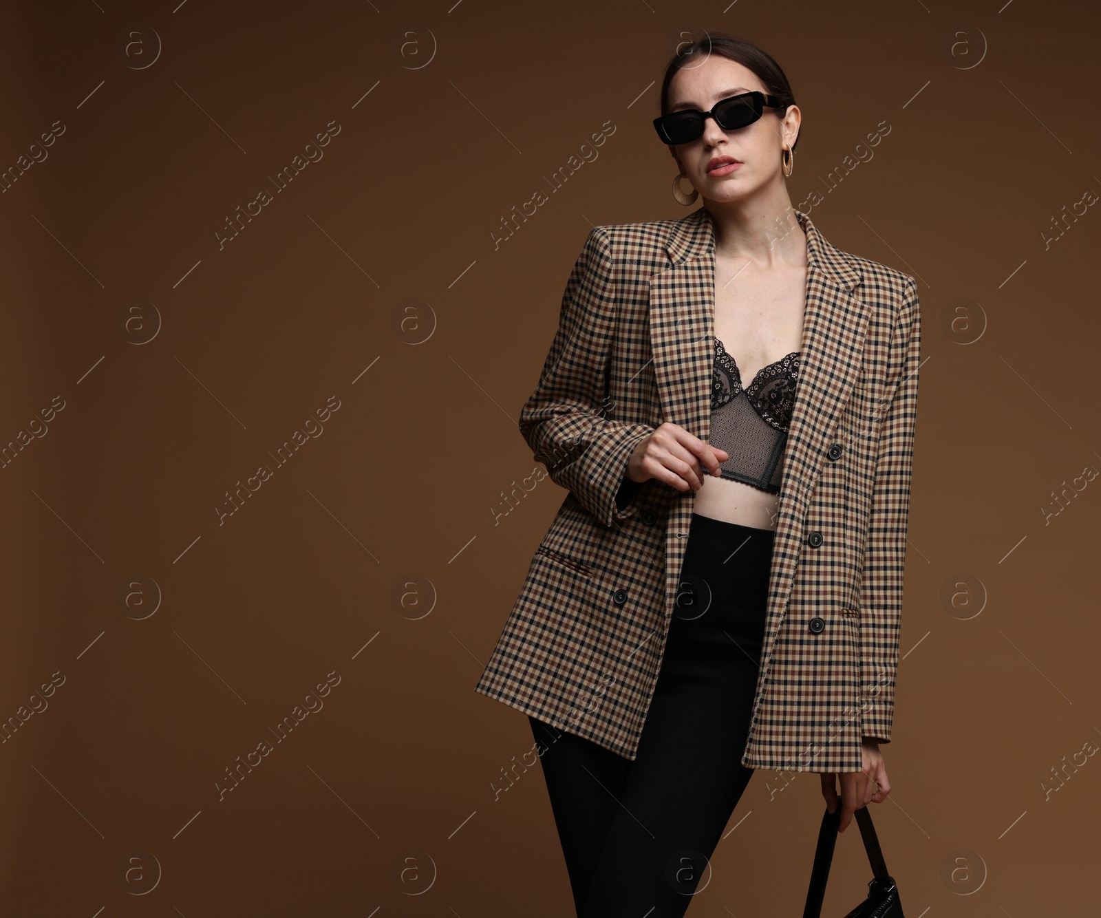 Portrait of beautiful woman in stylish outfit on brown background, space for text Photo of Portrait of beautiful woman in stylish outfit on brown background, space for text