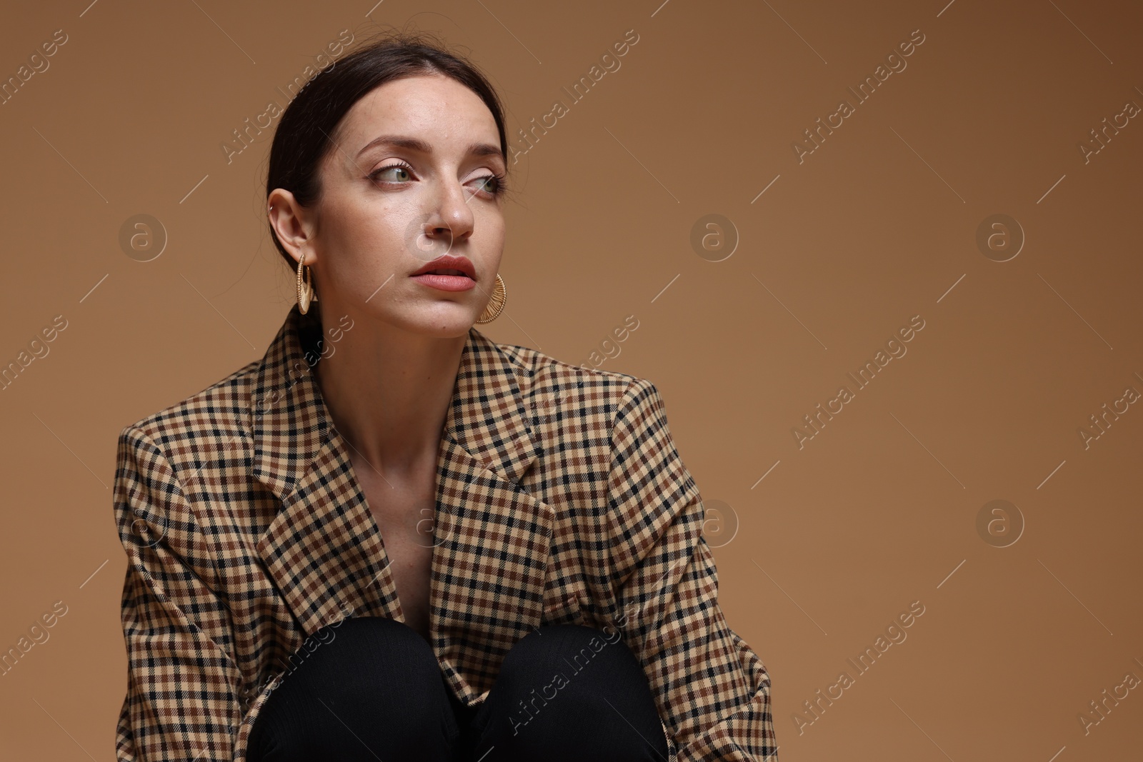 Portrait of beautiful woman in stylish outfit on beige background, space for text Photo of Portrait of beautiful woman in stylish outfit on beige background, space for text
