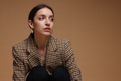 Photo of Portrait of beautiful woman in stylish outfit on beige background, space for text