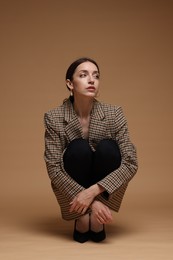 Photo of Full-length portrait of beautiful woman in stylish outfit on beige background